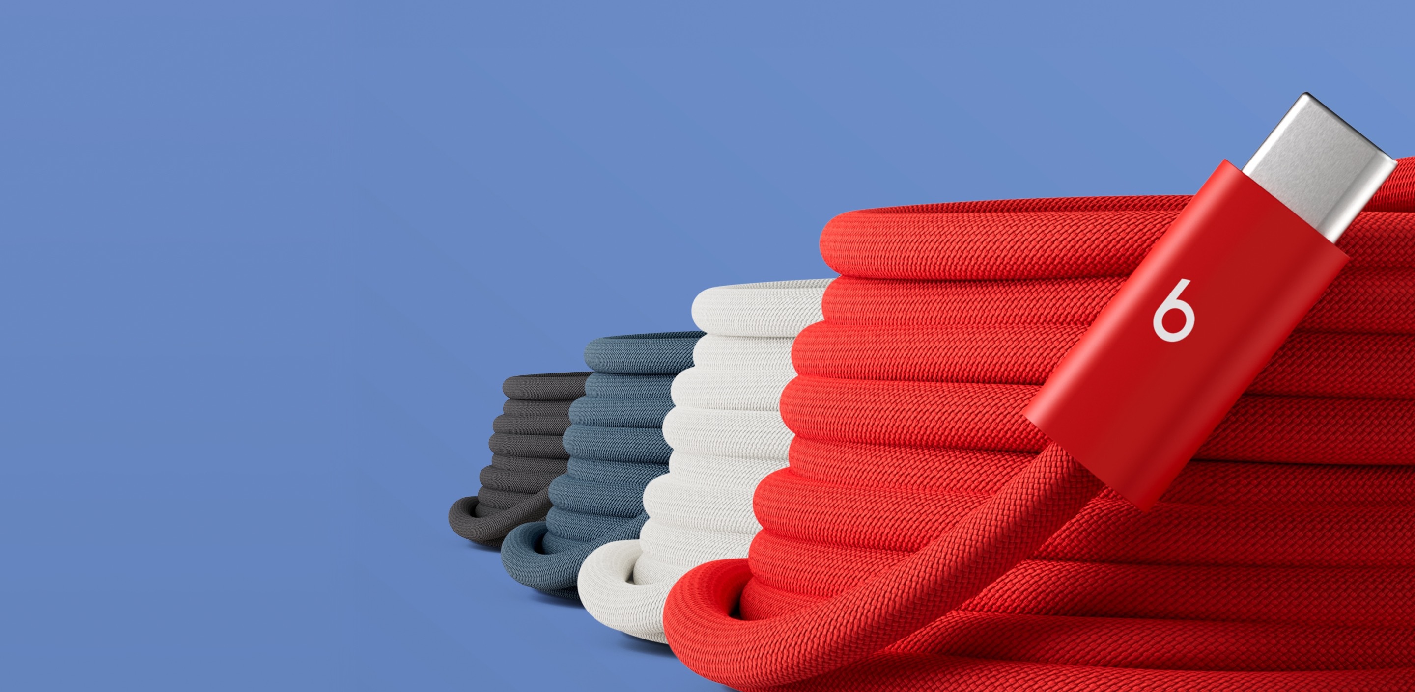 Coiled Beats 3-meter USB-C charging cables in four colors — Rapid Red, Surge Stone, Nitro Navy, and Bolt Black — stacked together against a blue background.