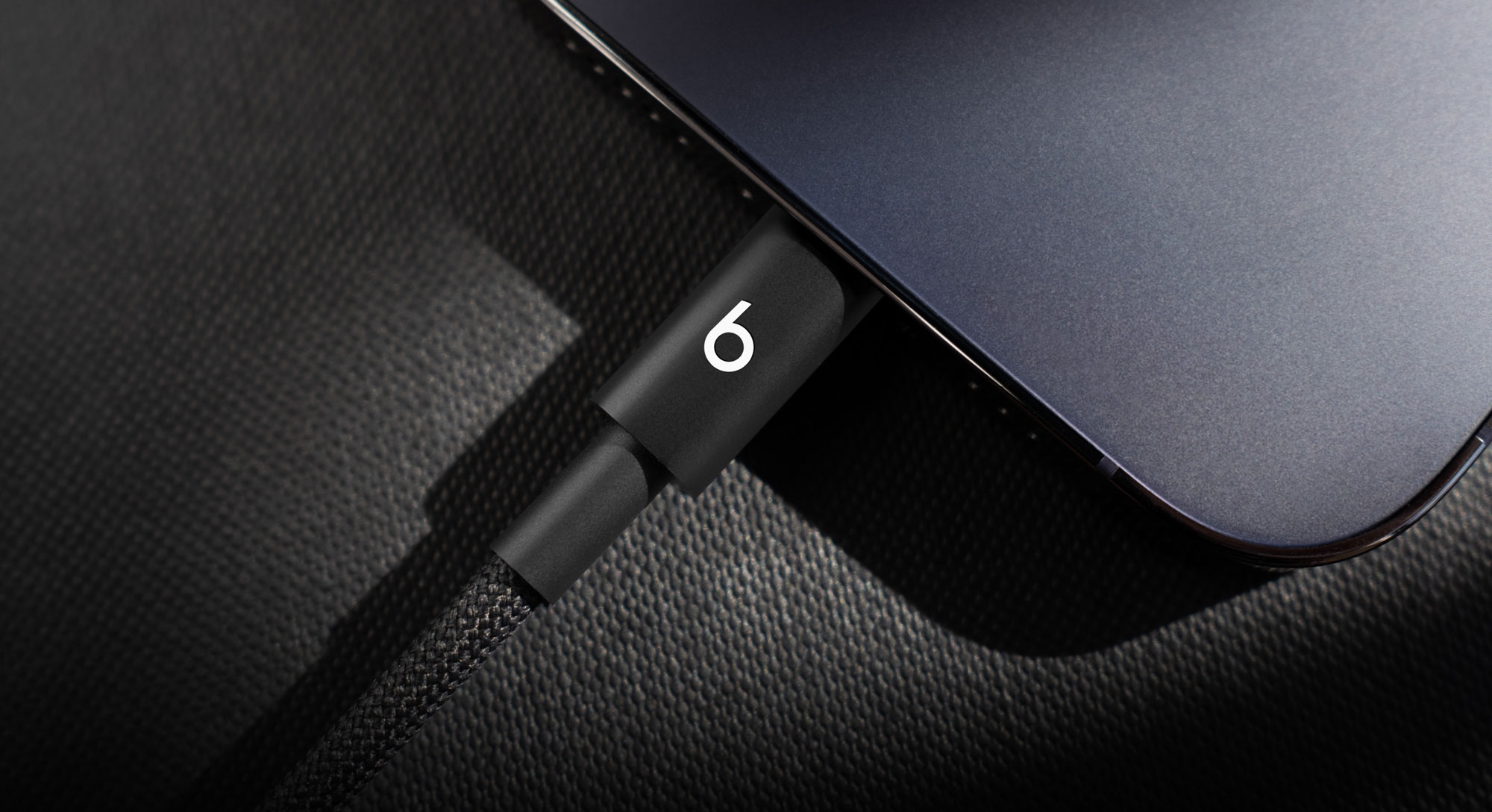 Person plugging in the Beats USB-C to USB-C Woven Cable into an iPhone.