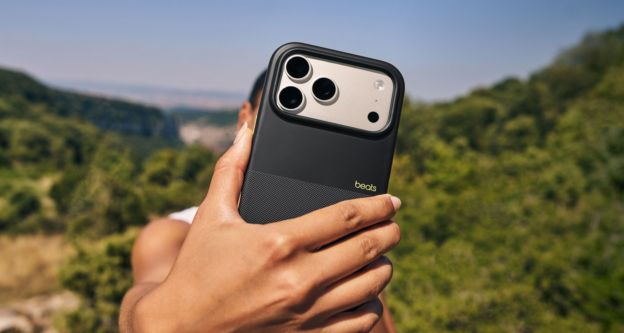 A person holding the Beats iPhone 17 rugged case with MagSafe and Camera Control in Everest Black showing the textured matt exterior to demonstrate its non-slip grip.