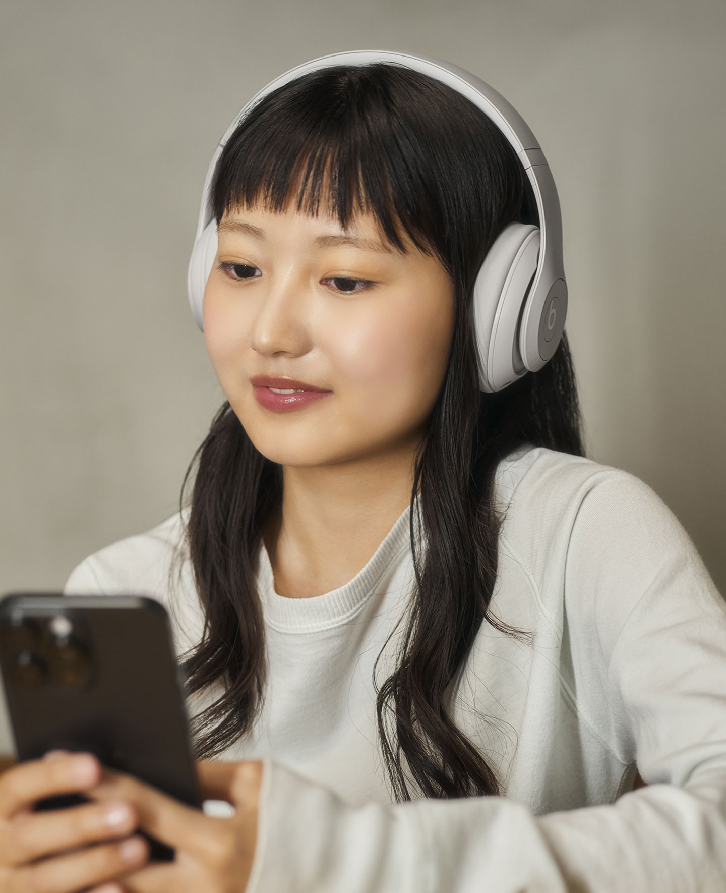 Beats Studio Proワイヤレスヘッドホン（サンドストーン）を装着しながら通話をしている人物